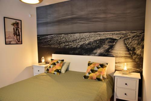een slaapkamer met een bed met een schilderij aan de muur bij Olive Apartman in Alsóörs