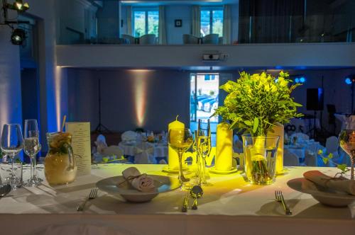 a table with a white table cloth with yellow flowers and glasses at Salón MISSEN in Trenčianske Teplice