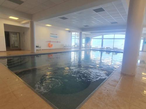une piscine vide dans un grand bâtiment dans l'établissement La Mongie Appartement duplex 7 personnes, à Bagnères-de-Bigorre