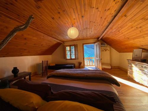 - une chambre avec un grand lit au plafond en bois dans l'établissement La coume du cerf, à Campan