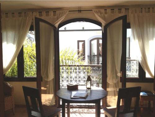 mesa y sillas en una habitación con ventana en Darcilla Guest House, en Tarifa