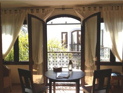 a table and chairs in a room with a window at Darcilla Guest House in Tarifa