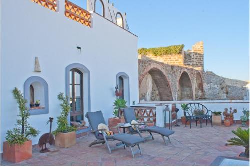 a patio with chairs and tables in a building at Darcilla Guest House in Tarifa