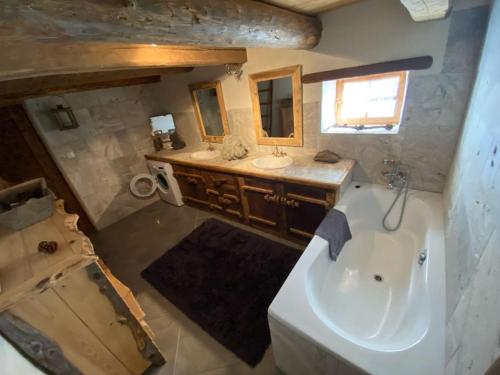 a bathroom with a tub and a sink and a mirror at La coume du cerf in Campan