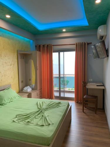 a bedroom with a bed with a blue ceiling at Hotel Besa in Shëngjin