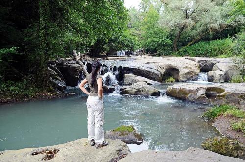 a woman standing on a rock in front of a waterfall at Casa di Augusto in Bomarzo