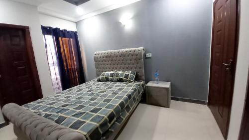 een slaapkamer met een bed met een getuft hoofdeinde bij Peaceful Low cost 2BR in Islamabad