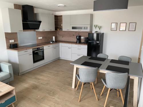 a kitchen with a table and chairs in a room at Haus Edith in Sassnitz