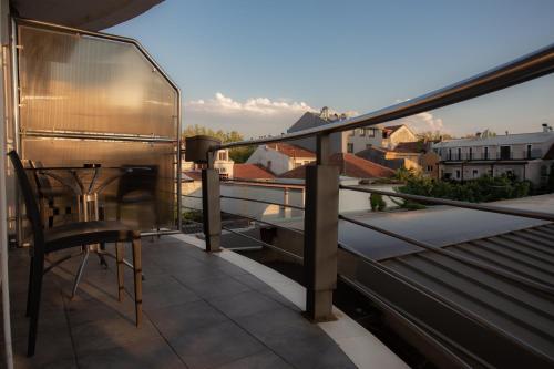 a balcony with a table and a view of a city at Hotel Alexandar Lux in Podgorica