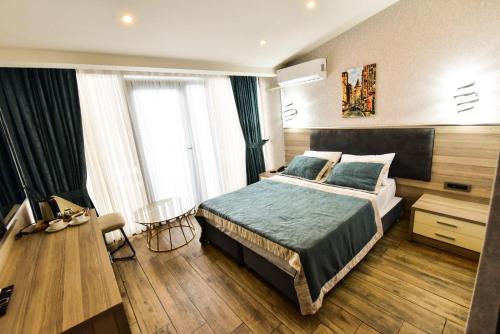 een slaapkamer met een bed, een tafel en een stoel bij RESTWON SUIT in Istanbul