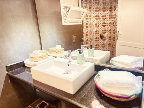 een badkamer met een witte wastafel en een spiegel bij Casa Do Cairo - Rehab City in Caïro