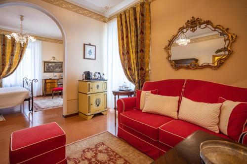 a living room with a red couch and a bedroom at Hotel Villa Marsili in Cortona