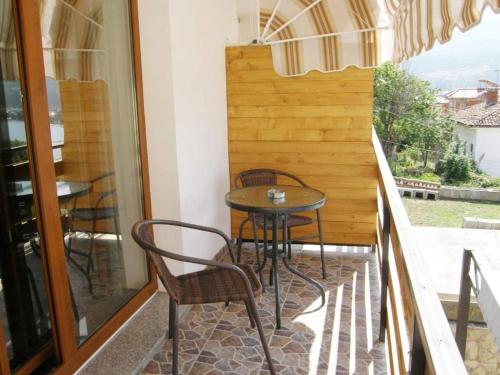 een patio met een tafel en stoelen op een balkon bij Villa Scandik Ohrid in Ohrid