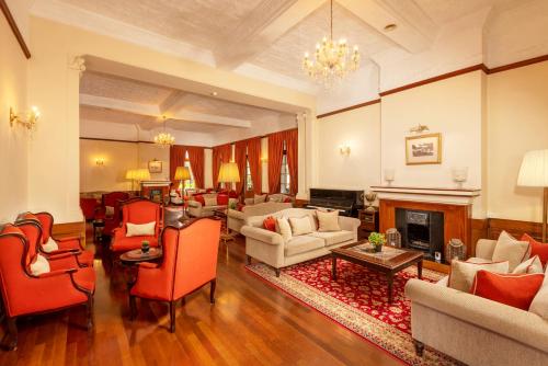 a living room filled with furniture and a fireplace at The Grand Hotel - Heritage Grand in Nuwara Eliya
