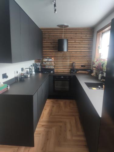 cocina con armarios negros y suelo de madera en Single bedroom in quiet neighbourhood en Mount Vernon