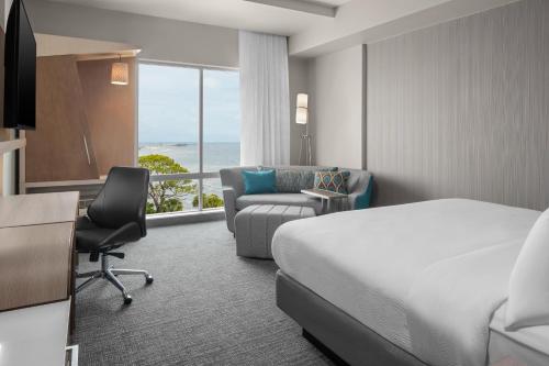 a hotel room with a bed and a desk and a chair at Courtyard By Marriott Titusville Kennedy Space Center in Titusville