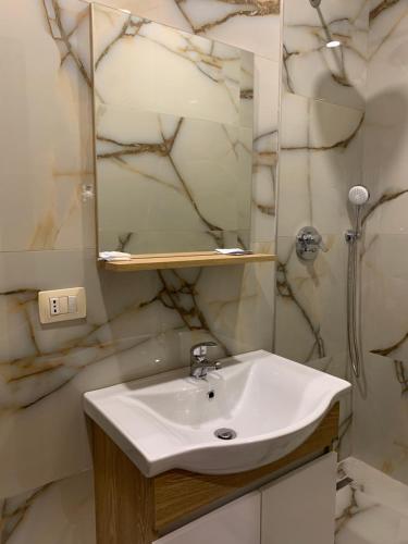 a bathroom with a sink and a mirror at Hotel Besa in Shëngjin