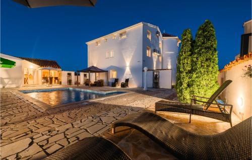 une villa avec une piscine la nuit dans l'établissement Awesome Home In Valtursko Polje With Kitchen, à Valtura