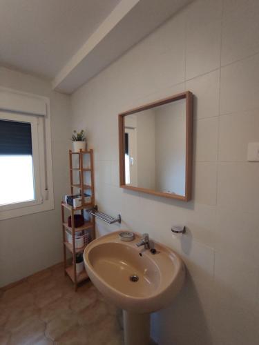 baño con lavabo y espejo en la pared en Piso con vistas a la Ría. 6 personas O Grove (Meloxo), en O Grove