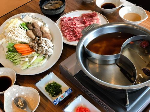 a table with plates of food and a pot of soup at Breezbay Seaside Resort Matsushima in Matsushima
