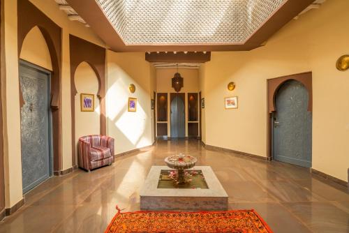a living room with a table in the middle of a room at Taj Atlas Wellness Boutique Hôtel & Spa in Amizmiz