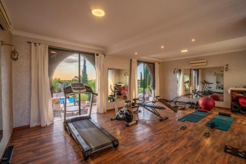 a gym with several treadmills and exercise equipment in a room at Taj Atlas Wellness Boutique Hôtel & Spa in Amizmiz