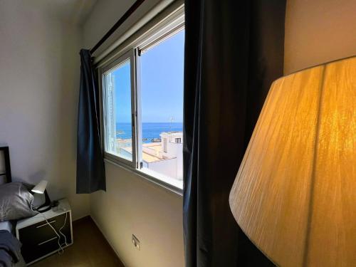 a bedroom with a window with a view of the ocean at Alquiler de Habitacion Privadas con Baño compartido Y áreas comunes in Alcalá