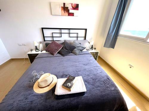 a bedroom with a large bed with a hat and glasses at Alquiler de Habitacion Privadas con Baño compartido Y áreas comunes in Alcalá