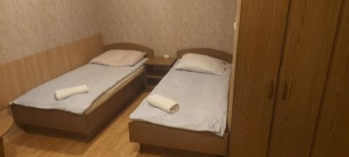 2 łóżka pojedyncze w małym pokoju z: w obiekcie Jovena Hostel w Wilnie