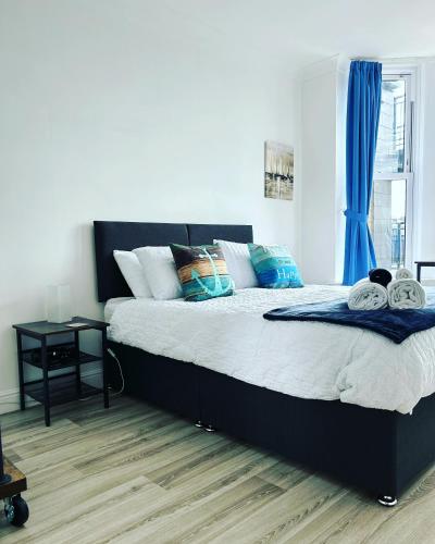 a bedroom with a large bed with blue curtains at Keepers Rest Apartment - Scarborough in Scarborough