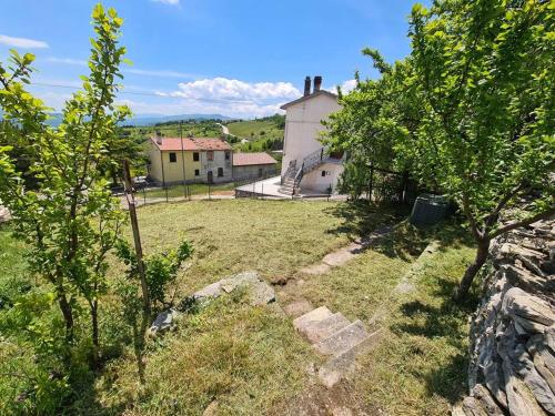 um quintal com árvores e uma casa ao fundo em Nonna Dorina Casa Vacanze em Pietrabbondante