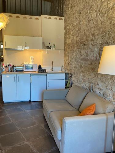a living room with a couch and a kitchen at 13 QUAI JEAN JAURES in LʼIsle-sur-la-Sorgue