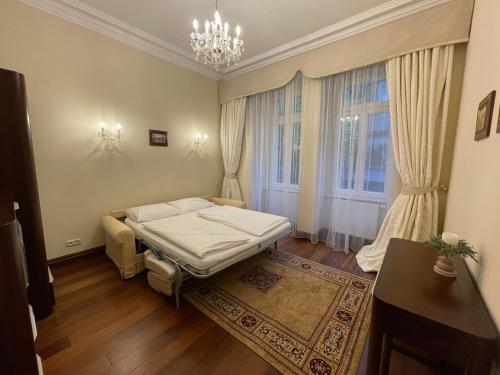 a bedroom with a bed and a window and a chandelier at Apartma Premium in Karlovy Vary