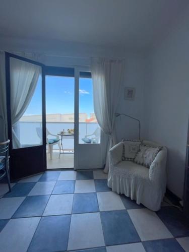 - un salon avec une chaise et une vue sur l'océan dans l'établissement Helios Canet Plage Sea View, à Canet