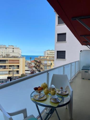 une table avec des assiettes de fruits sur un balcon dans l'établissement Helios Canet Plage Sea View, à Canet
