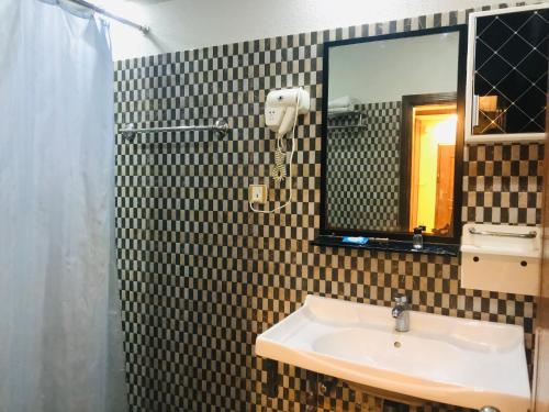 拉合爾的住宿－Pool & Park Hotel，一间带水槽和镜子的浴室