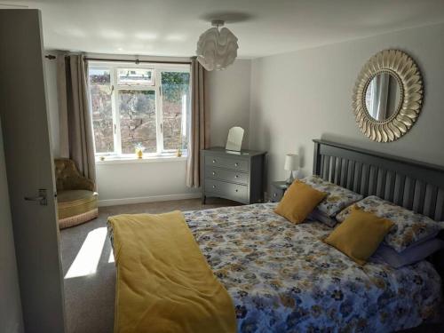 a bedroom with a bed and a mirror and a window at Applegrove, perfect 2 bed bungalow, Fortrose in Fortrose