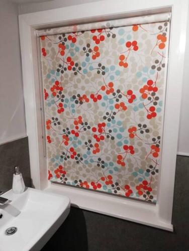a bathroom with a window with a floral pattern on it at Applegrove, perfect 2 bed bungalow, Fortrose in Fortrose