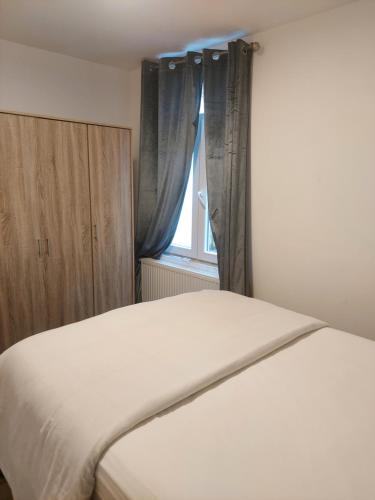 a bed in a room with a window at Maison fontaine du saxophone in Dinant
