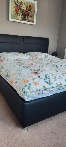 a bed with a floral comforter in a bedroom at Ferienhaus in der Hansestadt mit Blick auf Ostsee in Wismar