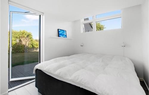ein Schlafzimmer mit einem Bett und einem großen Fenster in der Unterkunft 3 Bedroom Gorgeous Home In Ebeltoft in Ebeltoft