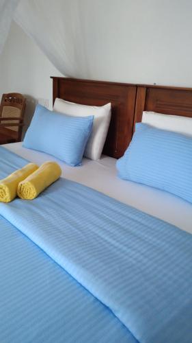 a bed with two yellow pillows on top of it at Holly House Homestay in Ella