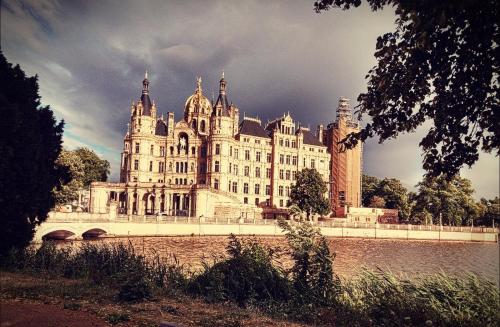 duży budynek z mostem przed rzeką w obiekcie Ferienhaus in der Hansestadt mit Blick auf Ostsee w mieście Wismar