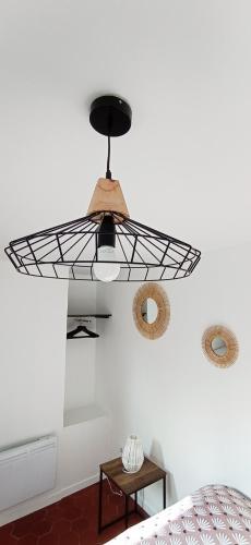 - une chambre avec un ventilateur de plafond noir et un lit dans l'établissement La Douce Cathare, à Carcassonne