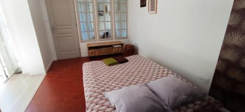 Un dormitorio con una cama en la esquina de una habitación. en La Douce Cathare, en Carcassonne