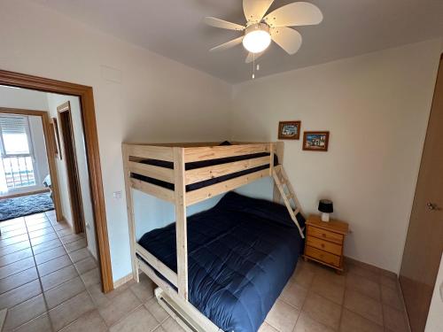 Łóżko piętrowe w pokoju z wentylatorem sufitowym w obiekcie Casa adosada con piscina y dos terrazas w mieście Alcossebre