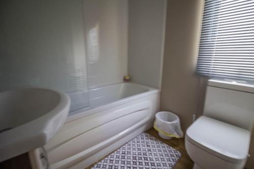 La salle de bains est pourvue d'une baignoire, de toilettes et d'un lavabo. dans l'établissement Modern 6 Berth Caravan At Highfield Grange In Essex Ref 26609p, à Clacton-on-Sea