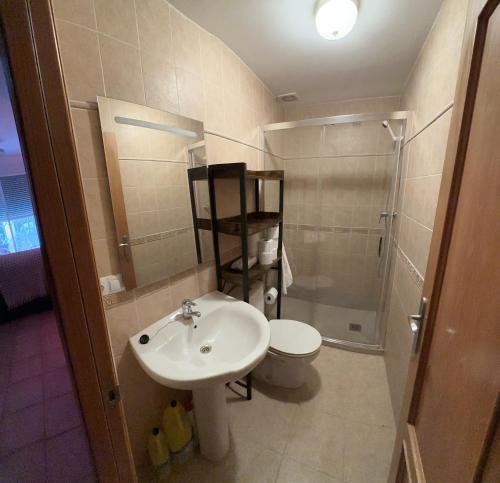 uma casa de banho com um lavatório, um chuveiro e um WC. em Casa adosada con piscina y dos terrazas em Alcossebre
