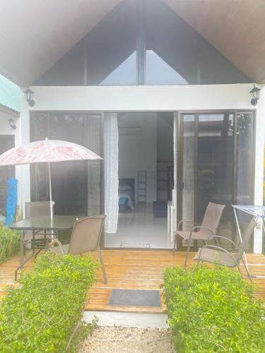 un patio con mesa, sillas y sombrilla en Villas Cabuya Beach & Jungle, en Cabuya