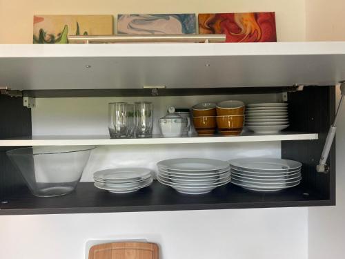 a shelf with plates and other dishes on it at Haus Ogertschnig Feichterwirth in Glanegg